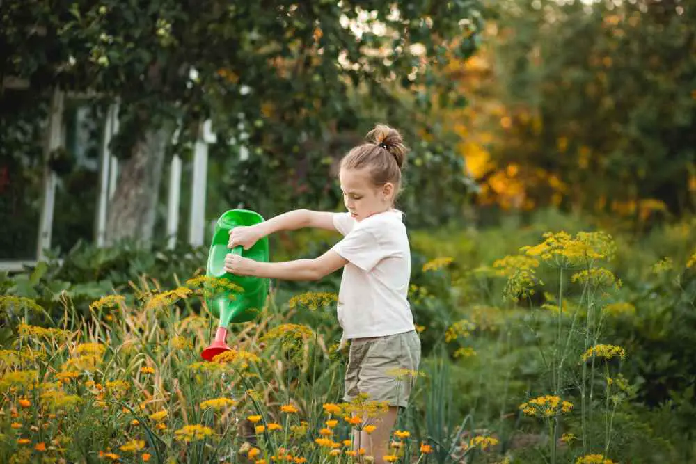 cute pre teen girl watering the garden in summer 2022 06 23 03 52 56 utc 1