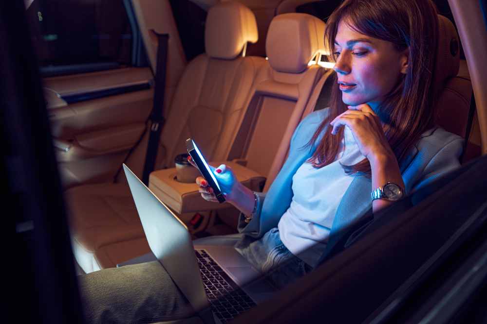 woman using mobile phone and laptop in car 2022 01 18 23 45 03 utc 1