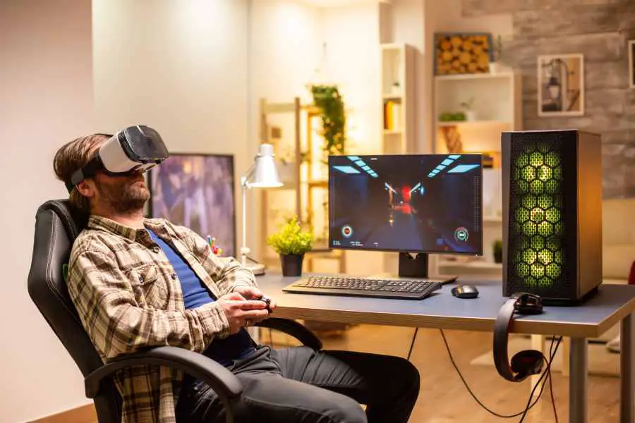 Professional gamer man using VR headset to play on a powerful PC late at night in his living room