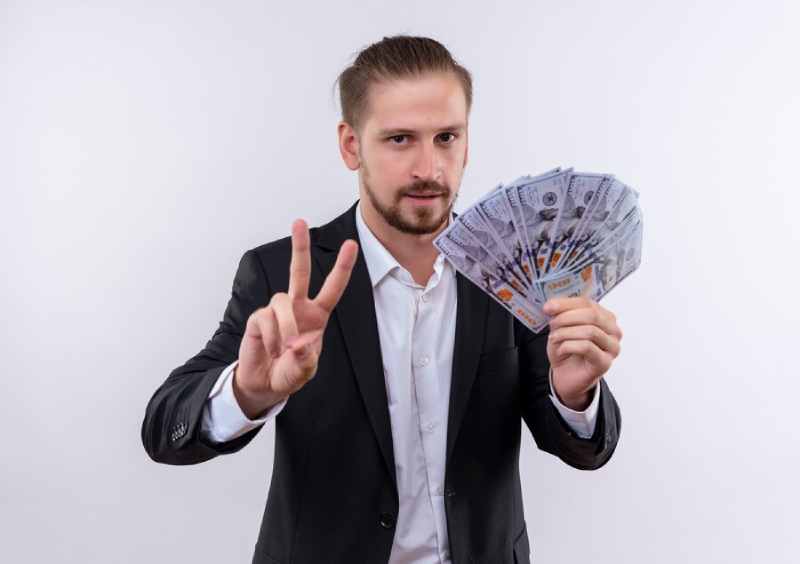 handsome business man wearing suit holding cash showing showing number two looking confident standing white background 141793 54039 1