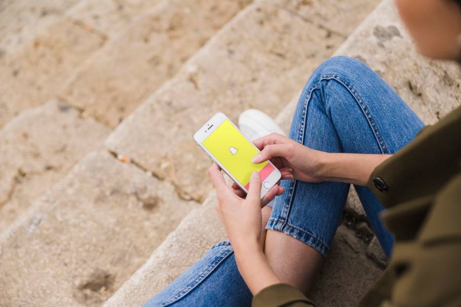 woman sitting staircase using snapchat app smartphone 1